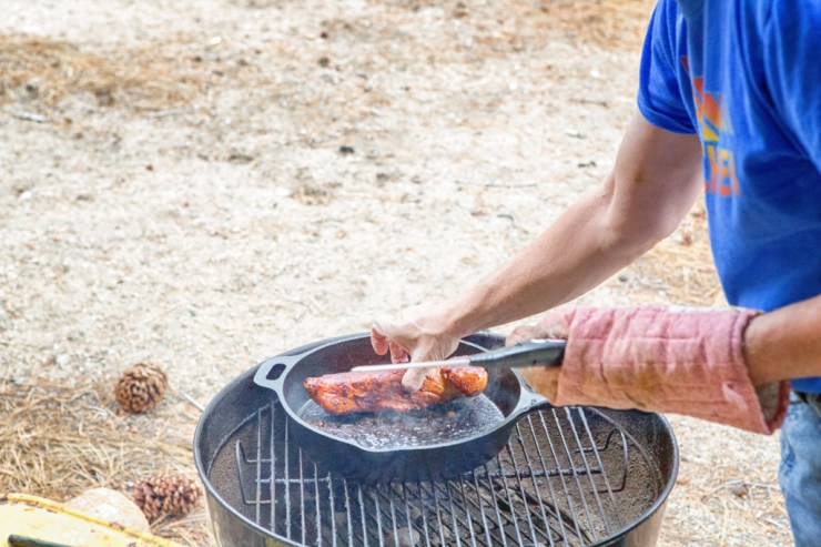 Squishing the meat to determine doneness