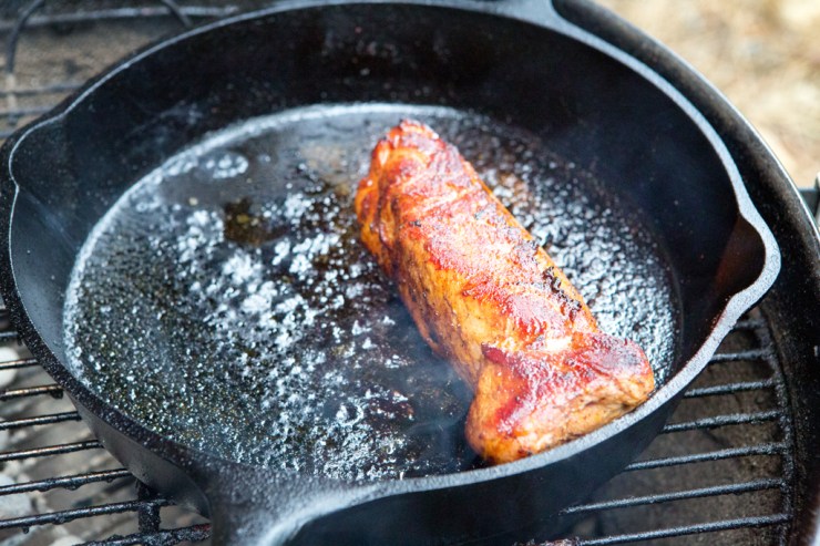 Grilling the pork in a skillet on the barbecue